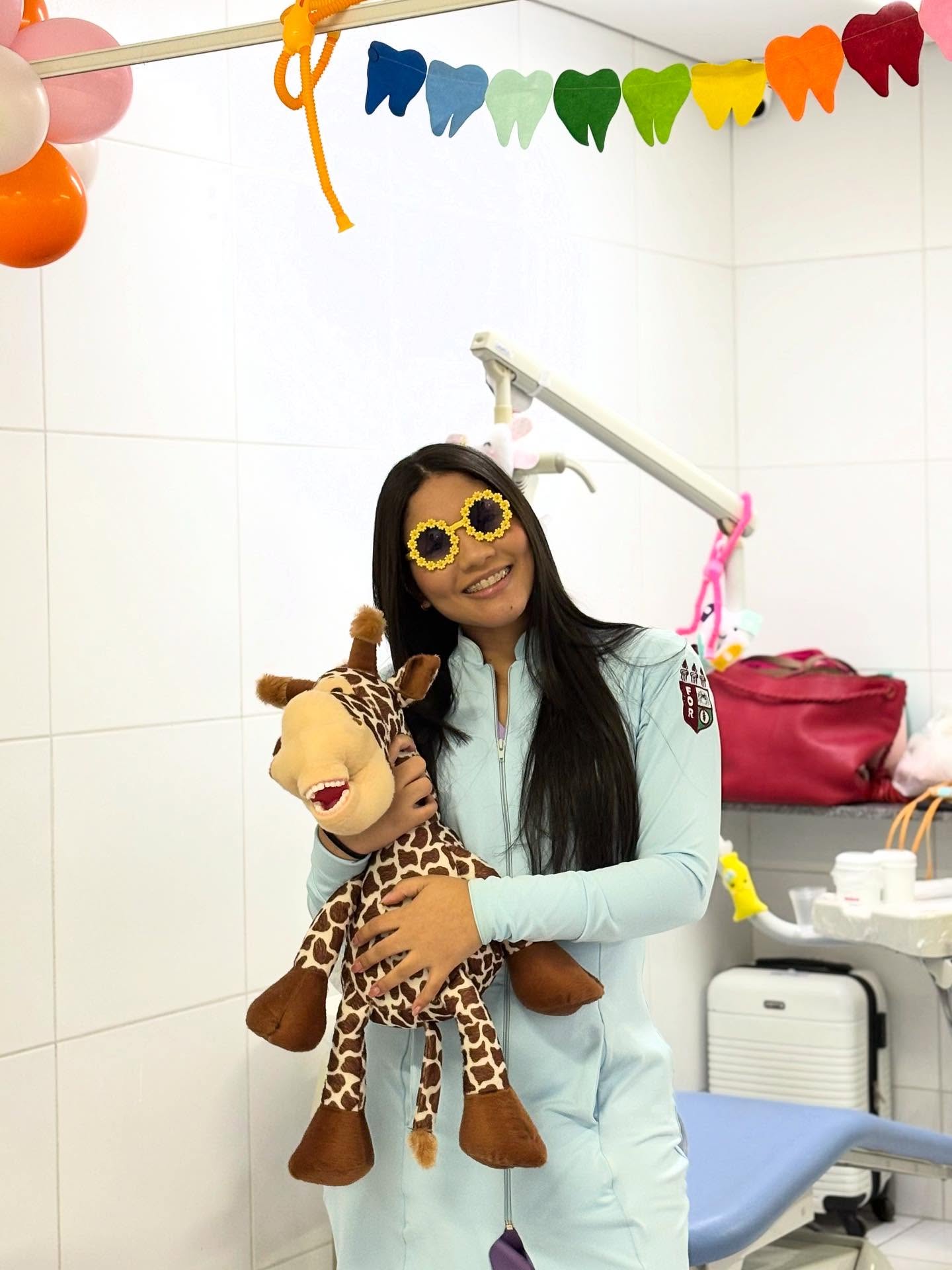 Dra. Thaís Oliveira com pelúcia na clínica